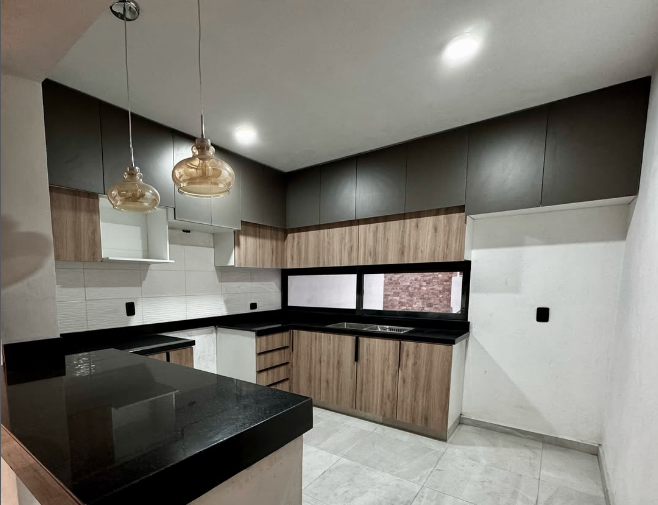 Cocina moderna con gabinetes de madera y encimeras oscuras